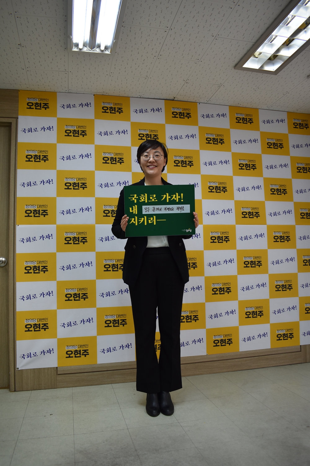 ▲오현주 정의당 후보자가 표어가 적힌 피켓을 들고 있다.